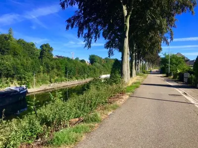 a path next to a river with trees on the side at Belle Chique - Maastricht in Lanaken