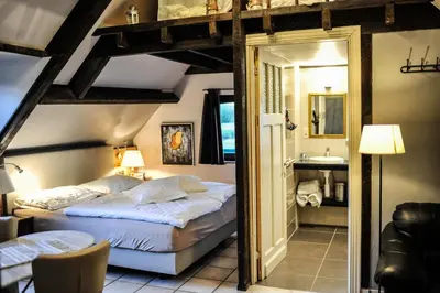 a bedroom with a king sized bed and a sink at B&B De Dubbelmolen in Tongeren