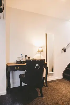 a desk with a chair in a room with a mirror at Hôtel Hors-Château - Liège Centre Historique in Liège