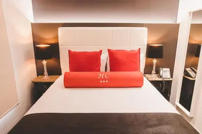 a bedroom with a bed with red pillows on it at Hôtel Hors-Château - Liège Centre Historique in Liège
