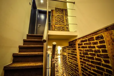 a staircase in a house with a brick wall at Hôtel Hors-Château - Liège Centre Historique in Liège