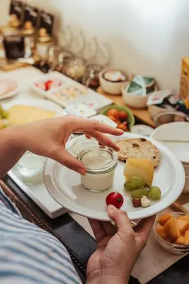 a person holding a plate with a jar of food at Hotel Het Buskruid in Lummen