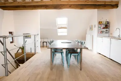 a kitchen and dining room with a wooden table and chairs at Maison Sainte-Marguerite in Liège