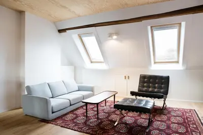 a living room with a couch and a chair at Maison Sainte-Marguerite in Liège
