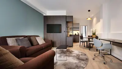 a living room with a couch and a dining room at Radisson Blu Hotel, Hasselt in Hasselt