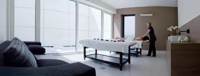 a woman standing next to a bed in a room at Carbon Hotel in Genk