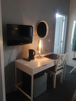 a desk with a television and a lamp on it at Eurotel in Liège