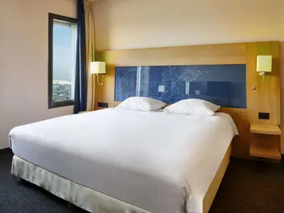 a large white bed in a hotel room with a window at Park Inn by Radisson Liege Airport in Liège