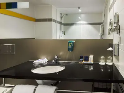 a bathroom with a black counter with a sink at Park Inn by Radisson Liege Airport in Liège