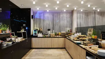 a restaurant with a counter with food on it at Park Inn by Radisson Liege Airport in Liège