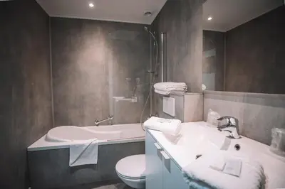 a bathroom with a sink and a toilet at Hotel Le Midi in Petit-Rechain