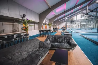 a living room with a couch and tables and chairs at Hotel Le Midi in Petit-Rechain