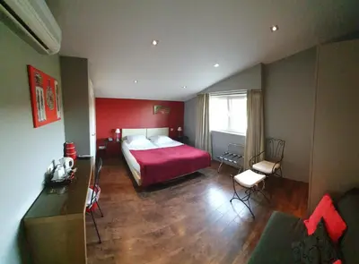 a bedroom with a bed and a red wall at B&B De Edelsteen in Zutendaal