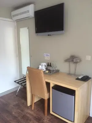 a room with a desk with a television on the wall at B&B De Edelsteen in Zutendaal