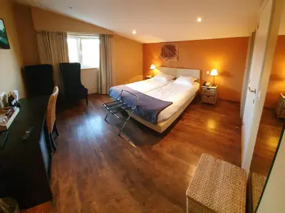 a hotel room with a bed and a table and chairs at B&B De Edelsteen in Zutendaal