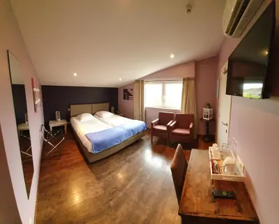a bedroom with a bed and a living room at B&B De Edelsteen in Zutendaal