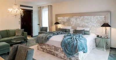 a bedroom with a large bed with a blanket on it at Le Chateau Des Thermes in Chaudfontaine
