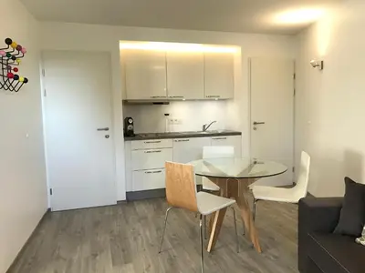 a kitchen and a dining room with a table and chairs at Xperience-Today Eupen in Eupen