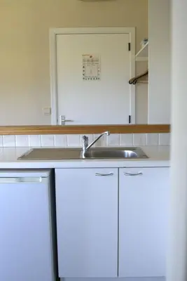 a kitchen with white cabinets and a sink at 't Gulpdal Hotel Voeren-Teuven in Voeren