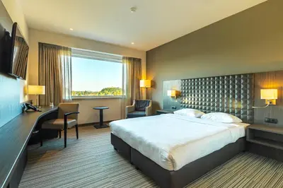 a hotel room with a bed and a large window at Mezzo Hotel & Business in Beringen