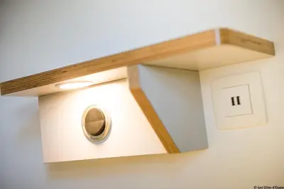 a wall mounted light with a wooden shelf at Gîte Kaleo Eupen Jugendherberge in Eupen