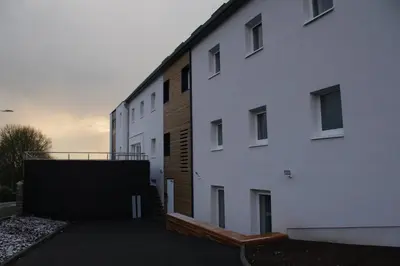 a large white building with a ramp next to it at Gîte Kaleo Eupen Jugendherberge in Eupen