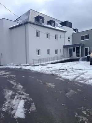 a large white building with snow on the ground at Gîte Kaleo Eupen Jugendherberge in Eupen