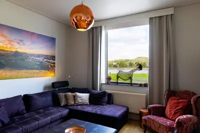 a living room with a purple couch and a window at De Koperen Geit in Kanne