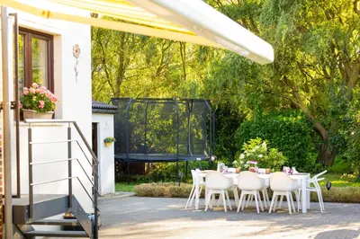 a table and chairs on a patio with a grill at De Koperen Geit in Kanne