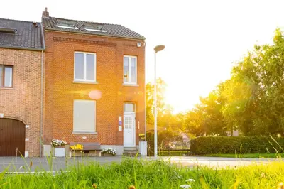 a brick house with a bench in front of it at De Koperen Geit in Kanne