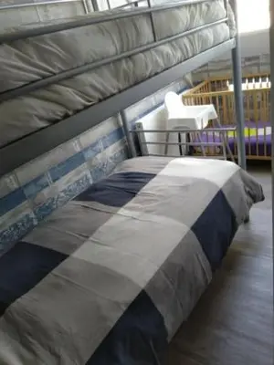 a bedroom with a bunk bed and a white chair at B&B Hoeven Het Gehucht in Overpelt