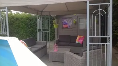 a porch with a couch and chairs under a canopy at B&B Hoeven Het Gehucht in Overpelt