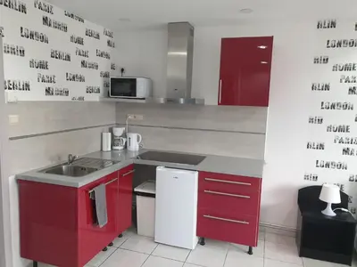 a kitchen with a sink and a red cabinet at Studio Filo in Liège