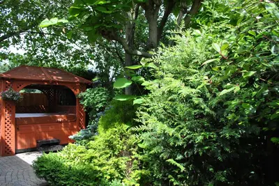 a garden with a gazebo and some bushes at B&B Elegance Hamont in Hamont-Achel