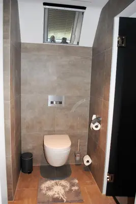 a small bathroom with a toilet and a window at B&B Elegance Hamont in Hamont-Achel