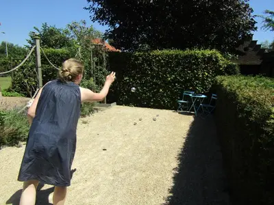 a woman throwing a ball in a garden at De Staberg in Bilzen