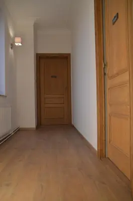an empty room with a door and a wooden floor at De Staberg in Bilzen