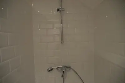 a shower with a shower head in a bathroom at De Staberg in Bilzen