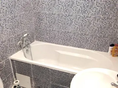 a bathroom with a white tub and a toilet at Appartement Au Coeur de Liege in Liège