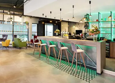 a bar in a restaurant with colorful stools at Park Inn By Radisson Hasselt in Hasselt