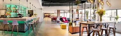 a restaurant with a bar and some chairs at Park Inn By Radisson Hasselt in Hasselt