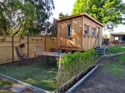a shed with a table and a bench in a yard at B&B Dream On Wheels in Lommel