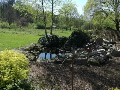 a rock garden with a pond and a water hose at Vakantieverblijf Volmolen B&B in Maaseik