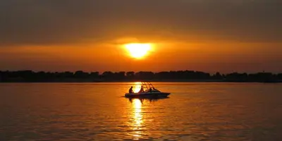 a boat on the water at sunset at B&B Orgel Thuis in Kinrooi