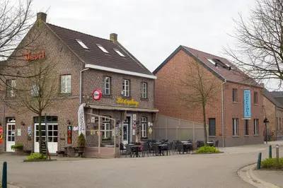 a brick building with tables and chairs in a street at B&B Orgel Thuis in Kinrooi