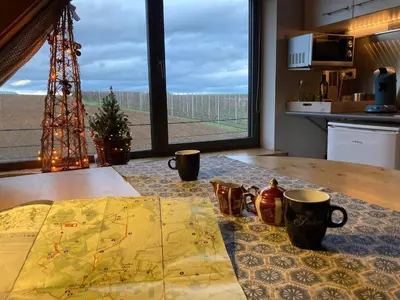 a table with two coffee cups and a map on it at Gastenverblijf Chambre dAmis in Heers