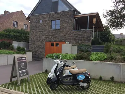a scooter parked in front of a house at Gastenverblijf Chambre dAmis in Heers