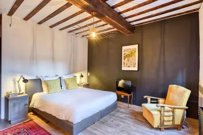 a bedroom with a bed and a desk and a chair at Chez Mamy in Liège