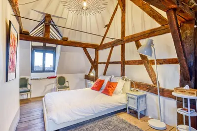 a bedroom with a bed in a room with wooden beams at Chez Mamy in Liège