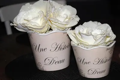 two cups filled with white flowers on a table at 't Poorthof in Borgloon